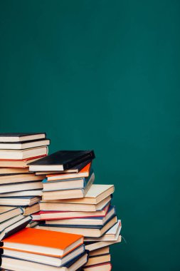 Üniversite sınavlarına hazırlanmak için yeşil bir arkaplan üzerine birçok eğitici kitap