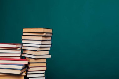 Üniversite sınavlarına hazırlanmak için yeşil bir arkaplan üzerine birçok eğitici kitap