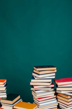 Üniversite sınavlarına hazırlanmak için yeşil bir arkaplan üzerine birçok eğitici kitap