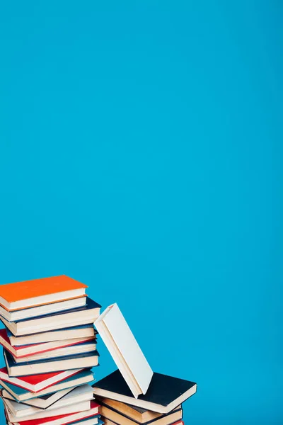 many of educational books for learning preparation for college exams on a blue background