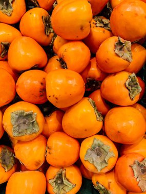 Arkaplan gibi yemek için bir sürü olgun, lezzetli portakal hurması.