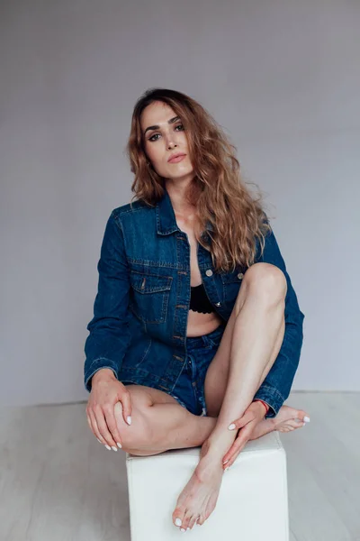 Ritratto di una bella donna in pantaloncini di jeans e lingerie — Foto Stock