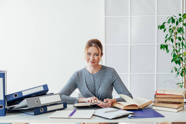 business woman working at a desk in the office with books training