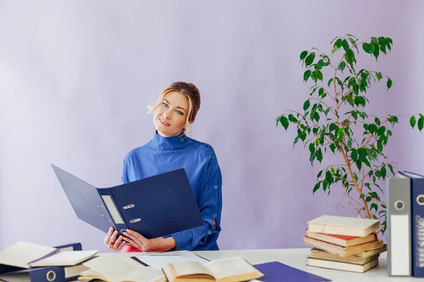 Mulher de negócios que trabalha em uma mesa no escritório com formação de livros — Fotografia de Stock