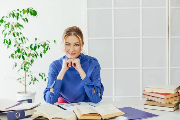 Mujer de negocios que trabaja en un escritorio en la oficina con la formación de libros — Foto de Stock