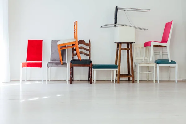 Different multicolored chairs in the interior of the white room — Stock Photo, Image