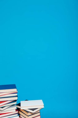 Kütüphanede öğretilecek bir sürü kitap mavi arka planda.