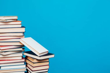 Kütüphanede öğretilecek bir sürü kitap mavi arka planda.