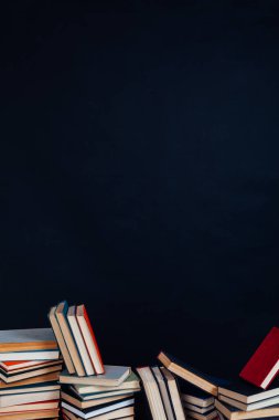 Kara arka planda, evin kütüphanesinde öğretecek bir sürü eğitim kitabı var.