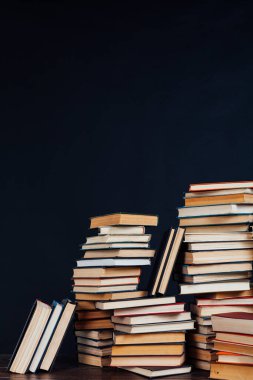 Kara arka planda, evin kütüphanesinde öğretecek bir sürü eğitim kitabı var.