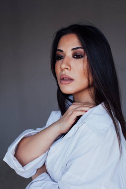 Beyaz gömlekli, doğulu, şık bir kadının portresi.