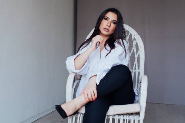 Beyaz gömlekli, doğulu, şık bir kadının portresi.