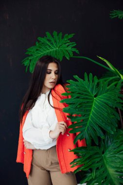 Doğulu, şık, iş elbisesi giymiş esmer bir kadının portresi.