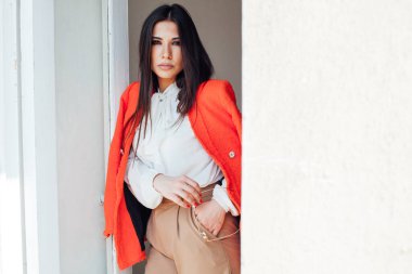 Doğulu, şık, iş elbisesi giymiş esmer bir kadının portresi.