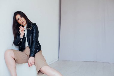 Siyah deri ceketli, doğu modasına uygun esmer bir kadının portresi.