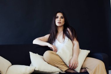 Evinde, kanepede güzel, doğulu bir kadının portresi.