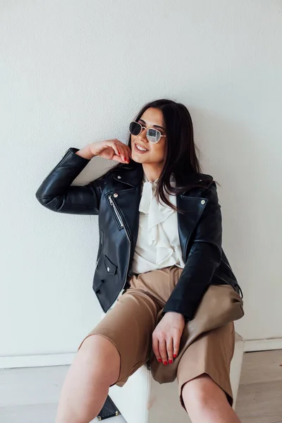 Портрет красивой модной брюнетки в черной куртке и очках — стоковое фото