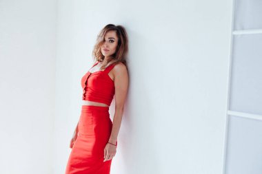 Beyaz arka planda kırmızı elbiseli güzel bir kadının portresi.