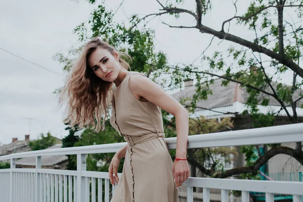 Retrato de una hermosa mujer de moda en un vestido beige para un paseo —  Fotos de Stock