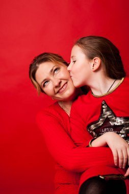 Kırmızı elbiseli anne-kız kucaklaşın.