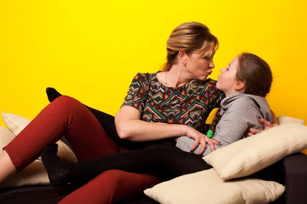 Mamma e figlia si siedono a casa in una stanza sul divano di famiglia — Foto Stock