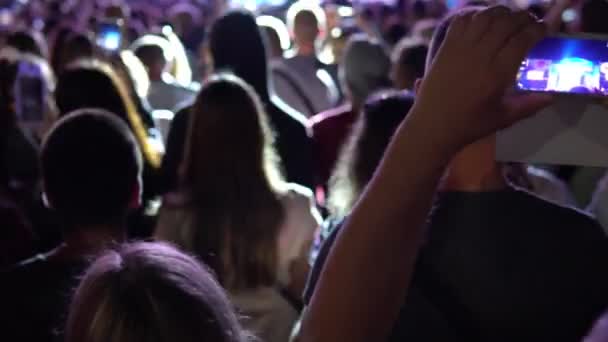 Толпа поддерживает людей, танцующих под музыку на концерте — стоковое видео