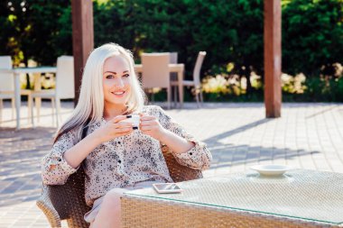 Güzel bir kadın restoranın kahvesinde oturuyor.