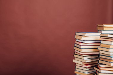 Üniversite kütüphanesinde kahverengi arka planda bir sürü eğitim kitabı var.