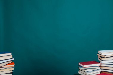 Üniversite kütüphanesinde yeşil arka planda bir sürü eğitim kitabı var.