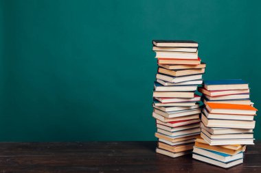 Üniversite kütüphanesinde yeşil arka planda bir sürü eğitim kitabı var.