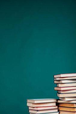 Üniversite kütüphanesinde yeşil arka planda bir sürü eğitim kitabı var.