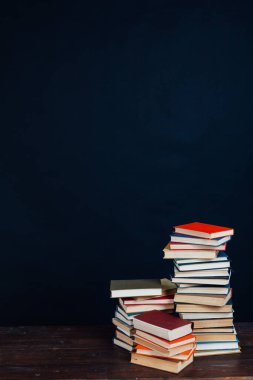 Üniversite kütüphanesinde siyah arkaplan üzerine bir sürü eğitim kitabı var.