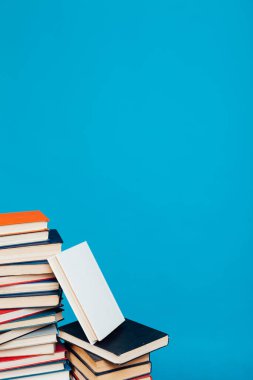 Üniversite kütüphanesinde mavi arka planda bir sürü eğitim kitabı var.