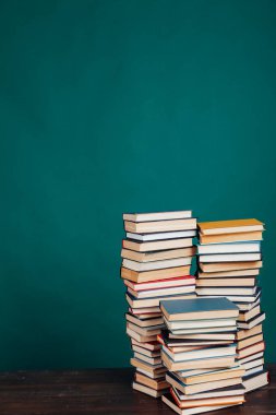 Üniversite kütüphanesinde yeşil arka planda bir sürü eğitim kitabı var.