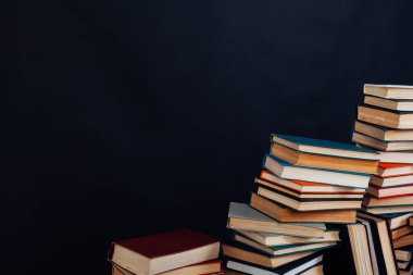 Üniversite kütüphanesinde siyah arkaplan üzerine bir sürü eğitim kitabı var.