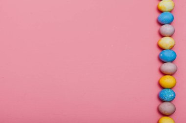 Paskalya tatili için pembe arka planda çok renkli yumurtalar