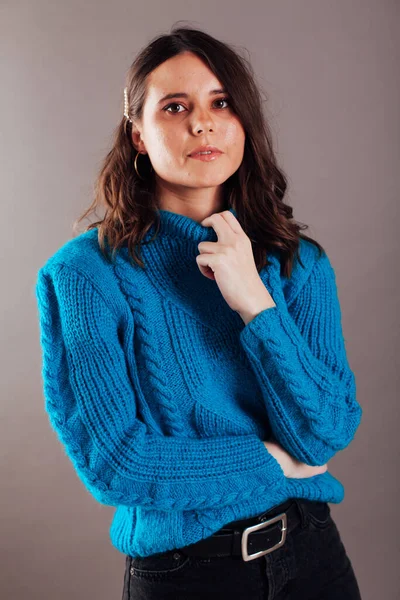 Retrato de uma bela jovem mulher morena na moda em uma camisola azul — Fotografia de Stock