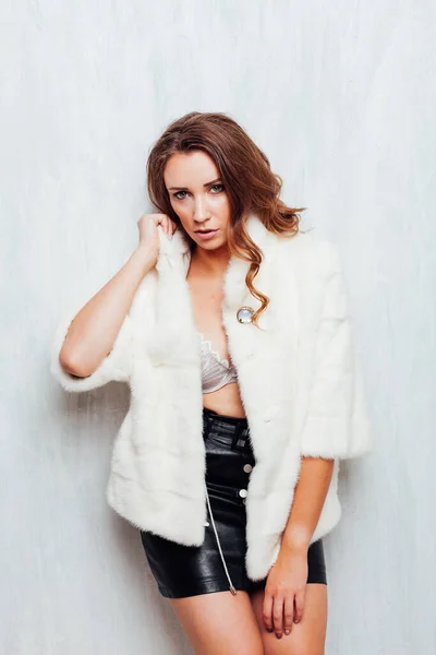 Portrait d'une belle femme avec des boucles en manteau de fourrure blanc et jupe noire — Photo