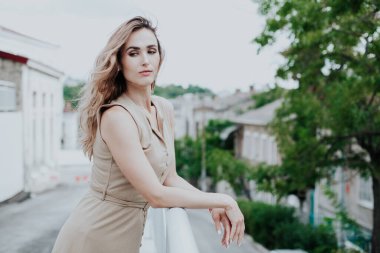 Bej elbiseli, şık, sarışın bir kadının portresi.