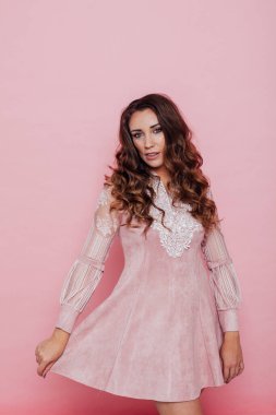 Pembe elbiseli, kıvırcık saçlı güzel bir kadının portresi.