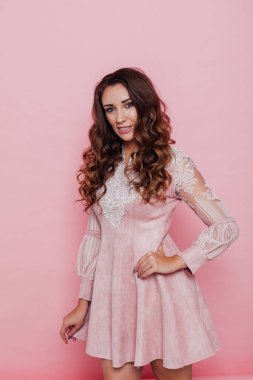 Pembe elbiseli, kıvırcık saçlı güzel bir kadının portresi.