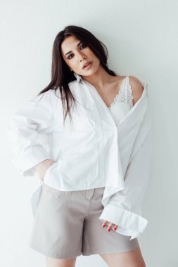 Beyaz tişörtlü ve şortlu güzel doğulu esmer kadın.