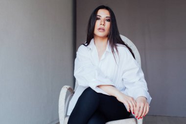 Güzel, modaya uygun, beyaz gömlekli esmer kadın.