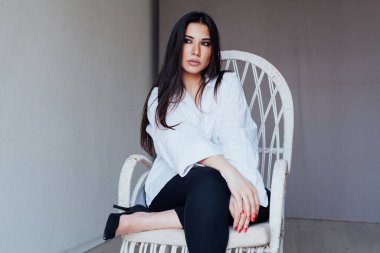 Güzel, modaya uygun, beyaz gömlekli esmer kadın.