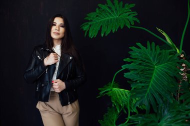 Güzel, modaya uygun, siyah deri ceketli esmer kadın.