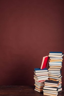 Üniversite kütüphanesinde kahverengi arka planda okuman gereken bir sürü eğitim kitabı var.