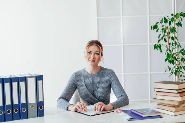 Portret bizneswoman przy stole z książkami i dokumentami w pracy w biurze — Zdjęcie stockowe