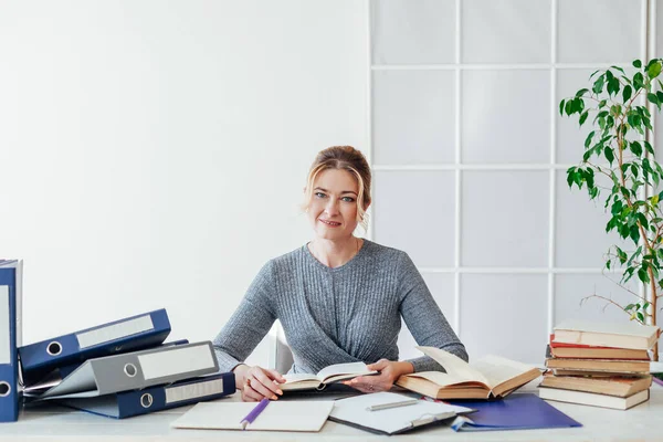 Portret bizneswoman przy stole z książkami i dokumentami w pracy w biurze — Zdjęcie stockowe