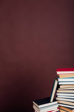 Üniversite kütüphanesinde kahverengi arka planda okuman gereken bir sürü eğitim kitabı var.