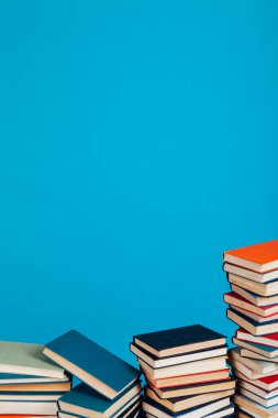 Okul kütüphanesinde mavi arka planda öğretilecek bir sürü eğitim kitabı var.